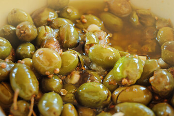 A traditional Cypriot preparation method for green olives. Green olives are picked and brocken wth a stone. Then they are taken out and marinated with olive oil, garlic, lemon and corainder seed