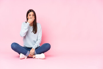 Young caucasian woman isolated on pink background covering mouth with hands