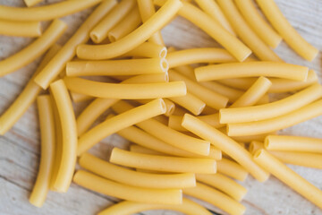 a lot of different kinds of egg noodles and yellow pasta on wooden background
