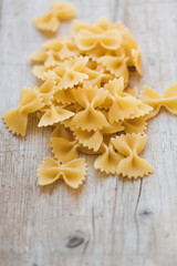a lot of different kinds of egg noodles and yellow pasta on wooden background