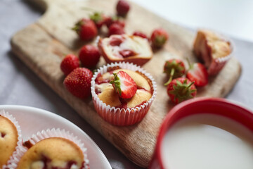 Homemade strawberry cupcakes on wooden cutting board - summer pasrty