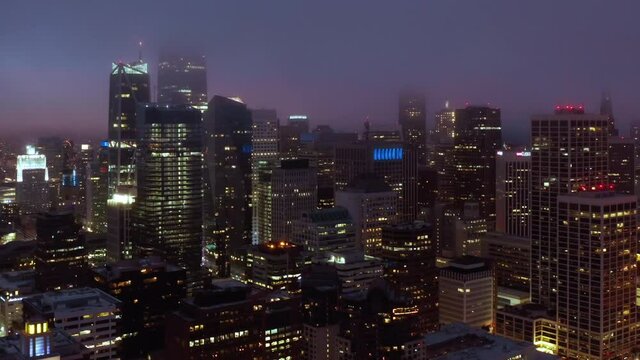 Technology capital, Silicon Valley, United States of America. Cinematic aerial panorama of beautiful downtown San Francisco at night. Scenic fog is covering illuminated skyscrapers towers. 4K drone