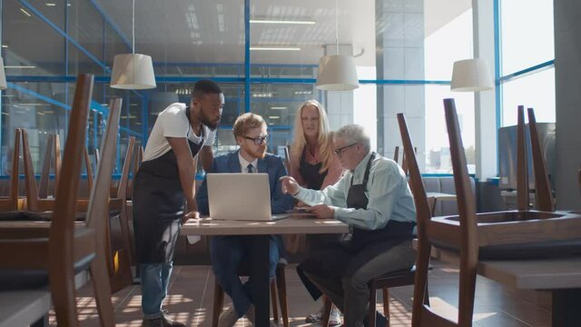 Multiethnic restaurant team using laptop ordering food supply online