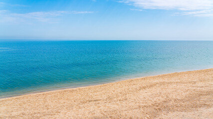 Fototapeta na wymiar Calm clear blue sea and white sand beach