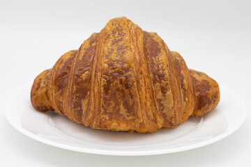 Large Delicious Croissant on a White Plate with a White Background