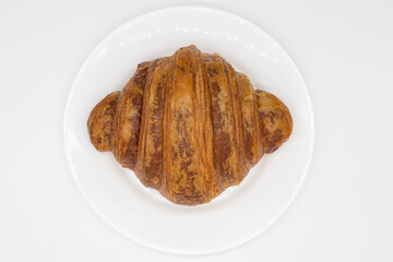 Large Delicious Croissant on a White Plate with a White Background