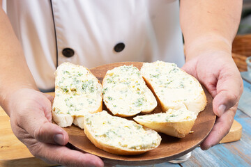 Chef show garlic bread on the wooden plate