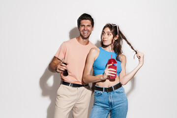 Image of pleased beautiful couple smiling while drinking beverages