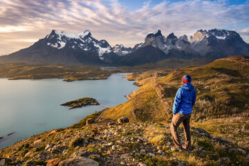 Solo traveler relaxing and meditating in front of the patagonian mountains and lakes.
Freedom lifestyle of an hiker immersed in nature. Chile - obrazy, fototapety, plakaty