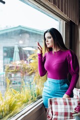 Beautiful model posing for photos. Wearing denim skirt and purple blouse.