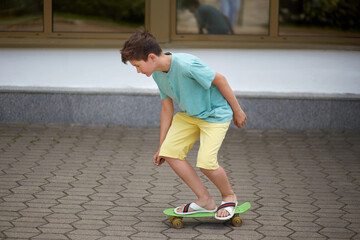 Handsome young guy teenager rides a skateboard. Focus on legs and skateboard.