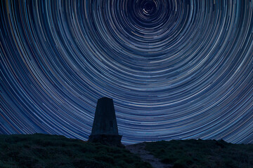 Digital composite image of star trails around Polaris with Beautiful Autumn Fall landscape of South Downs National Park - Powered by Adobe
