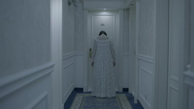 Terrifying ghost woman in bride gown standing near door, scary haunted hotel