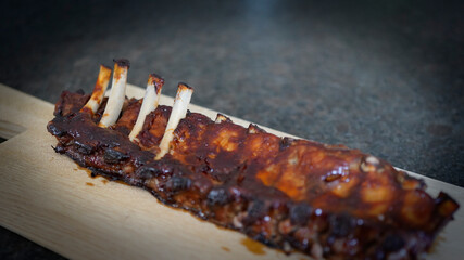 ready to eat - grilled delicous spareribs from a beef on a wood board