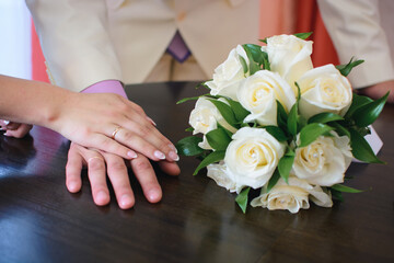 hands of the bride and groom with gold rings at the wedding