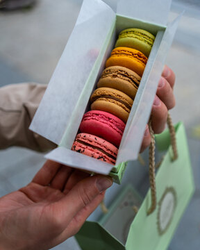 close up of a woman holding macaroons 