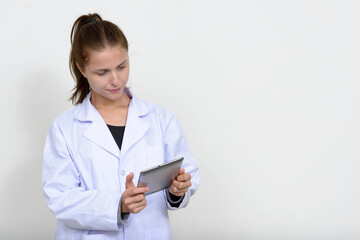 Portrait of young beautiful woman doctor against white background