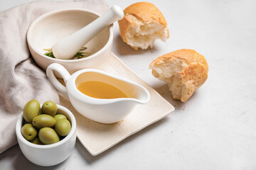 Gravy boat of tasty olive oil and bread on white background