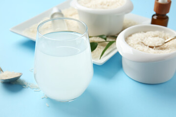 Glass of rice water on color background