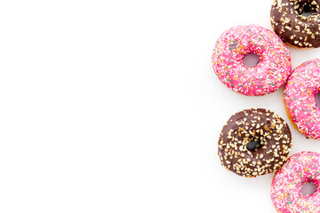Colorful donuts pink and chocolate icing. Flat lay of bakery, above view