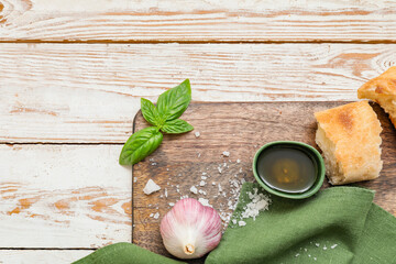 Bowl of tasty olive oil and bread on white wooden background