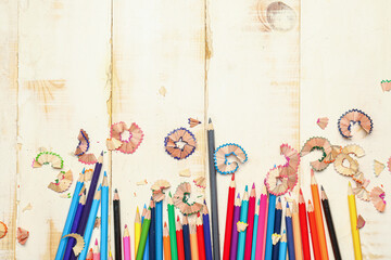 Ordinary pencils and shavings on wooden background