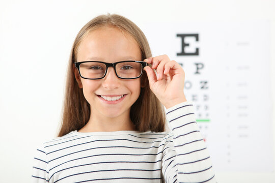 Cute little girl checks eyesight with an ophthalmologist. eyesight test