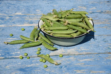 A seeds of peas in a bowl on wooden background.