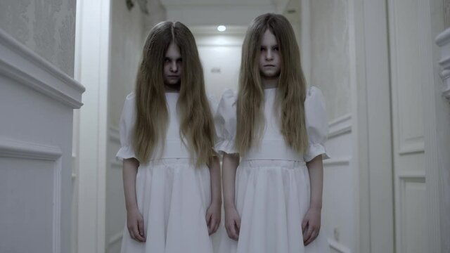 Little twin girls with deadly pale faces staring at cam, scary zombie creatures