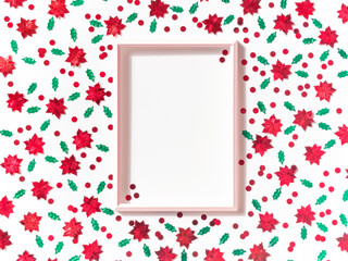Christmas composition. Template from a frame on a white background. Christmas decorations in the form of green leaves and red flowers. Christmas, winter, new year concept.  Flat lay. Copy space.