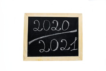 Inscription 2020 2021 chalk on a black chalkboard with a wooden frame on a white background.