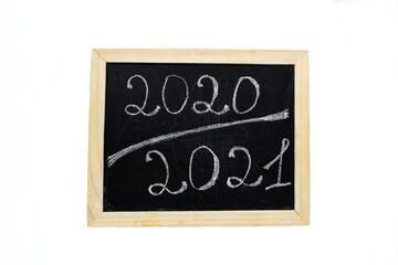 Obraz premium Inscription 2020 2021 chalk on a black chalkboard with a wooden frame on a white background.