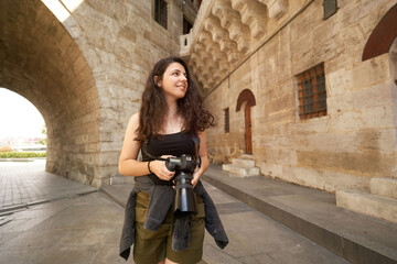 Female tourist is visiting historical places with camera. Photographer who visits historical places. The blogger who is happy to see new places. A woman going on a trip with a backpack and a camera. 