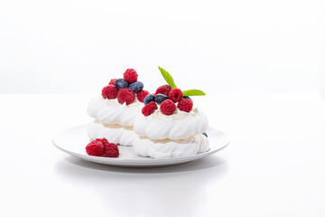 mini Pavlova dessert with raspberries and blueberries on the table