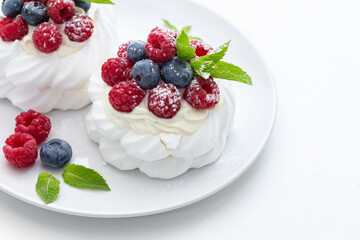 mini Pavlova dessert with raspberries and blueberries on the table