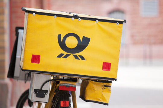 Logo of german mail - Deutsche Post - on yellow background on bicycle