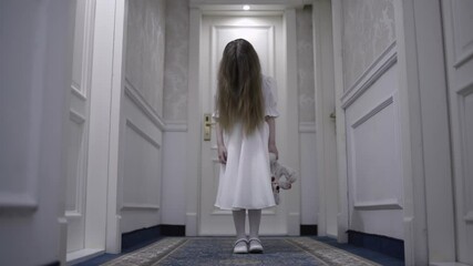 Terrible ghost child dropping bloody toy on floor, face hidden in hair, thriller
