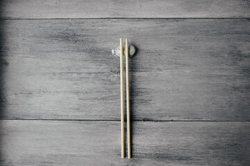 wooden chopsticks for chinese asian food on light wooden background and stone top view. Asian cutlery.
