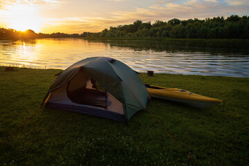 Rafting on kayaks. A tent camp stands on the river bank.