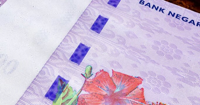 Close-up footage of one hundred Ringgit Malaysia. Detailed macro capture of brand new RM 100. Macro shot from the front of Malaysian money with the portrait of the first King or Agong. RM100