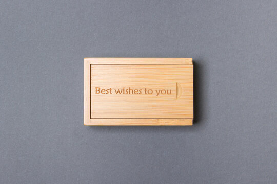 closed wooden box on gray colored paper background with inscription best wishes to you on top