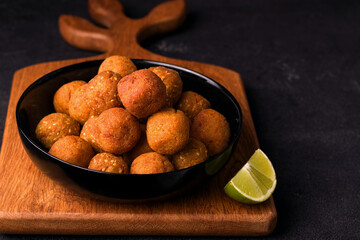 A Middle Eastern vegan dish, falafel. Fried ready-made chickpea balls in bowl on black background