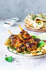 Grilled chicken kebabs (chicken skewers) with herbed garlic butter naan tortillas and Greek tzatziki sauce. Delicious street food.