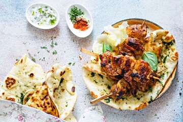 Grilled chicken kebabs (chicken skewers) with herbed garlic butter naan tortillas and Greek tzatziki sauce. Delicious street food.