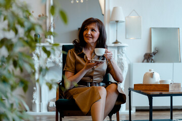 Beautiful Senior Woman Drinking Tea At Living Room and Smiling. Happy Active Life at Any Age....