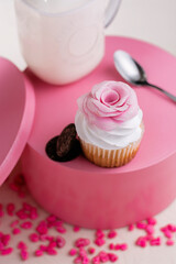 bizcocho con temática de amor y amistad  en una base rosa con una cuchara y un vaso de leche en el fondo  con chocolates y piedras rosas 