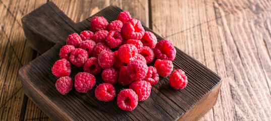 Sweet, ripe raspberries on a wooden background. Long banner
