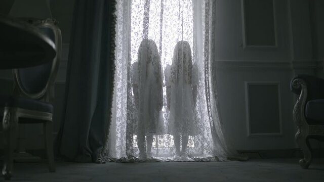 Nightmarish silhouettes of two little girls hiding behind curtains haunted house