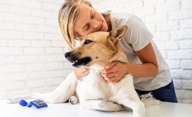 Young blond woman hugging her mixed breed dog