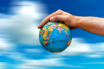 Conceptual symbol human hands surrounding the Earth world globe. the sky in motion